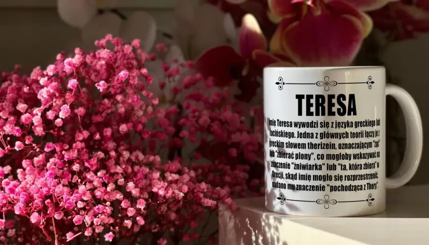 Kubek z imieniem Teresa na tle różowych kwiatów. Idealny prezent na imieniny Teresy.