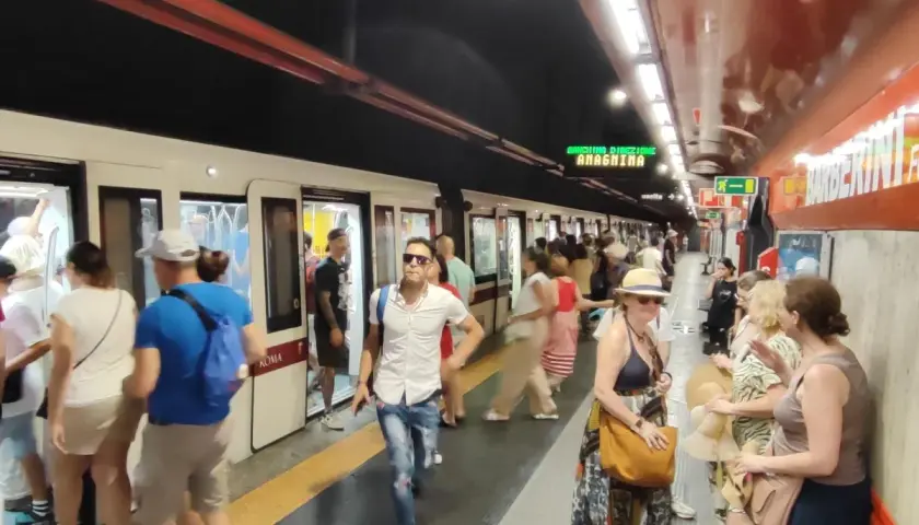 Persone in attesa del treno alla stazione Barberini di Roma.