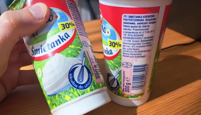 Dwie śmietanki 30% z karagenem, jedna w dłoni, gotowe do ubijania. Idealne do deserów.