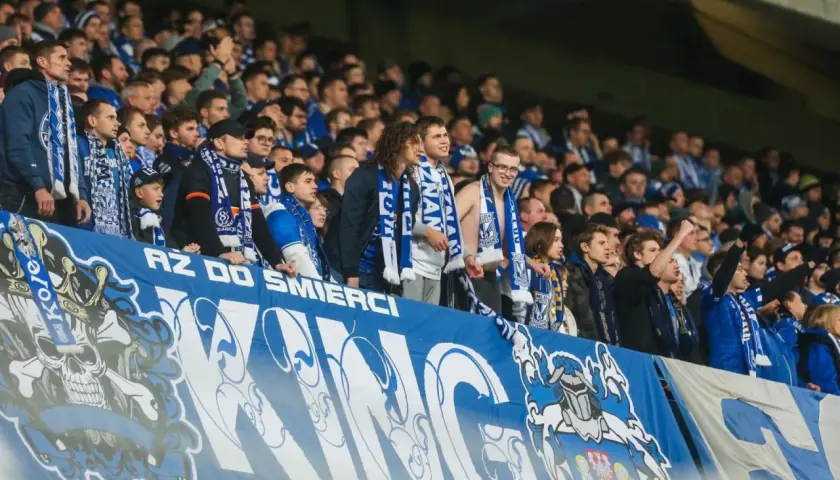 Kibice Lecha Poznań na europejskie puchary, z szalikami i transparentem "AZ DO ŚMIERCI".