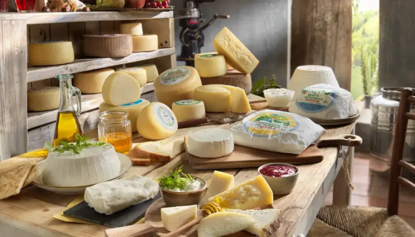 Un ricco assortimento per una presentazione tagliere formaggi: diverse varietà, miele, olio e pane su un tavolo rustico.