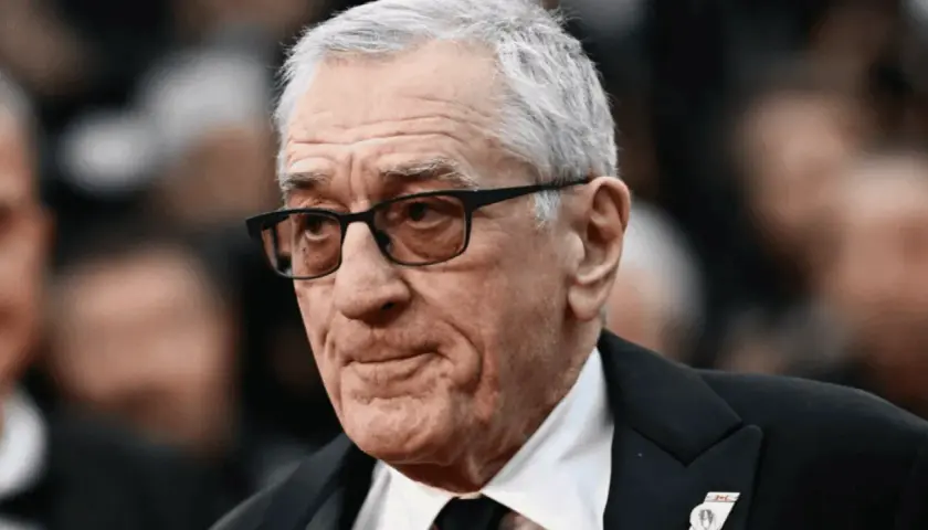 Portret Roberta De Niro w okularach, w garniturze.