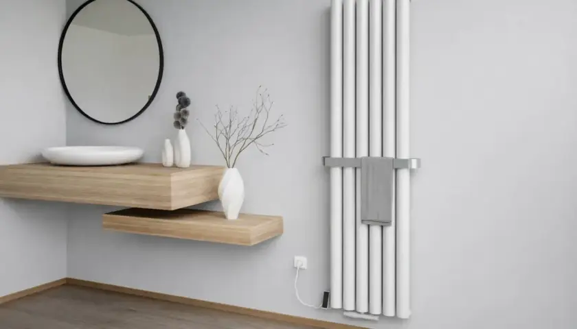 Nowoczesna łazienka z białym, pionowym grzejnikiem stalowym lub aluminiowym, wiszącą drewnianą umywalką i lustrem.