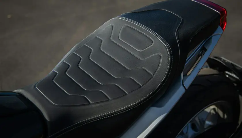 Cuscino sella moto fai da te con cuciture bianche e design geometrico. Comfort e stile per il tuo viaggio.