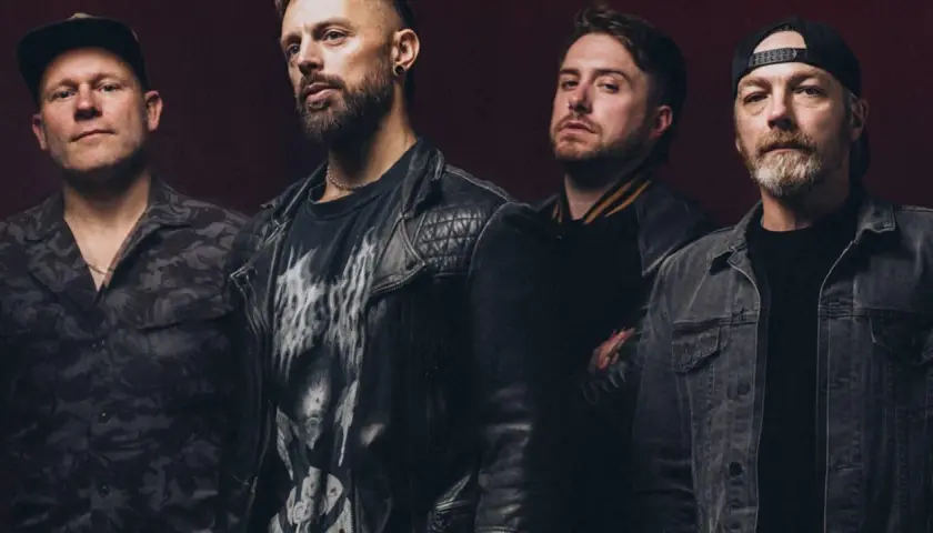 Czterech mężczyzn z zespołu Bullet for My Valentine Polska w rockowych stylizacjach, gotowi na koncert.