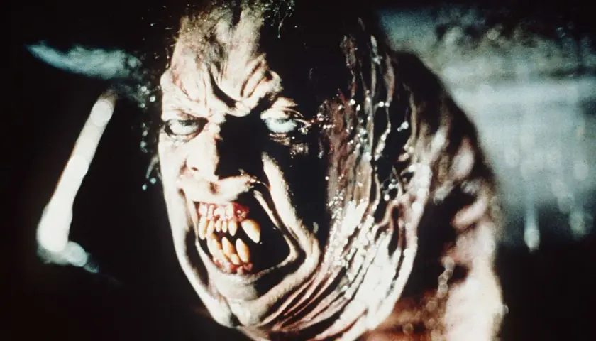Przerażająca twarz potwora z zębami jak sztylety, w stylu found footage horror.