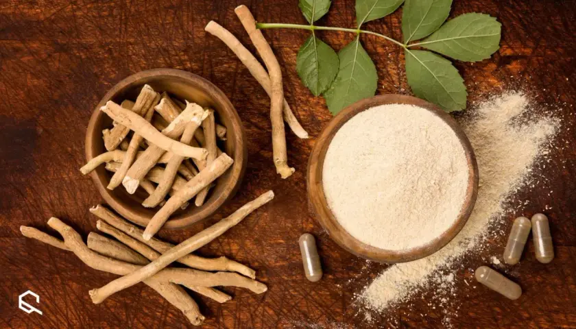 Radici, polvere e capsule di ashwagandha su fondo in legno, con foglie verdi. Ricerca e ashwagandha studi scientifici.
