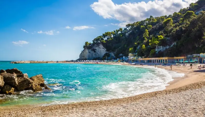 Spiaggia di Sirolo, Marche: mare cristallino, scogli e una collina verdeggiante fanno da cornice a questa perla adriatica.
