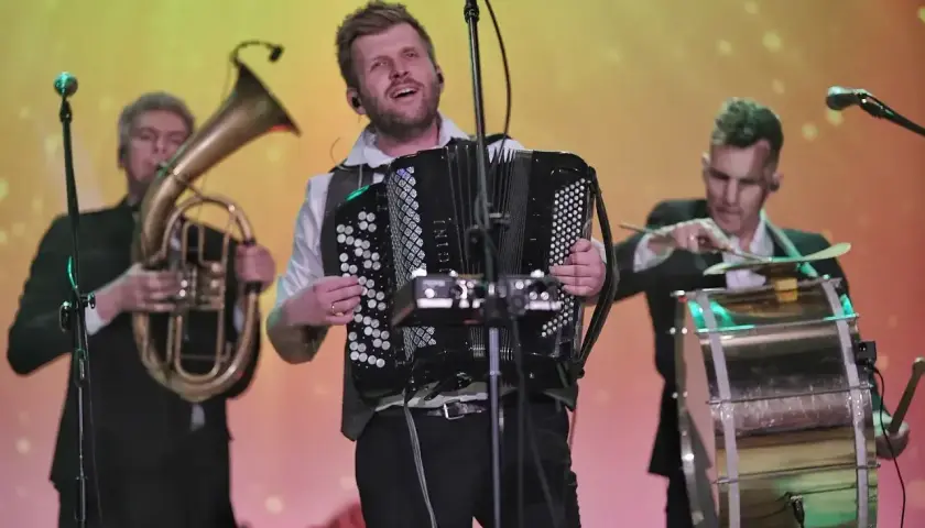 Bum bum orkestar w akcji: akordeonista, tubista i perkusista tworzą energetyczną muzykę na scenie.