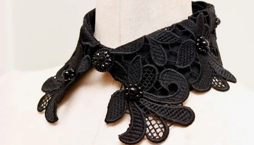 Intricate black lace collar with beaded embellishments, perfect for adding a touch of elegance. Learn how to make a lace collar with this detailed view.