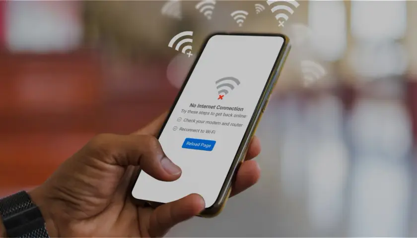 Dłoń trzyma smartfon z komunikatem "Brak połączenia z internetem". Czyżby awaria T-Mobile?