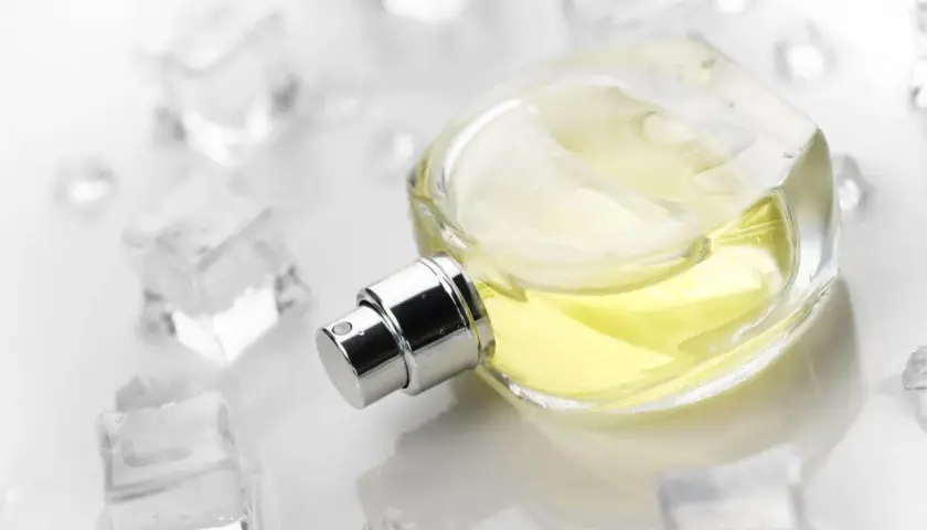 Elegancka butelka perfum z żółtym płynem, otoczona kostkami lodu. Zapach szyprowy, orzeźwiający jak zimny powiew.