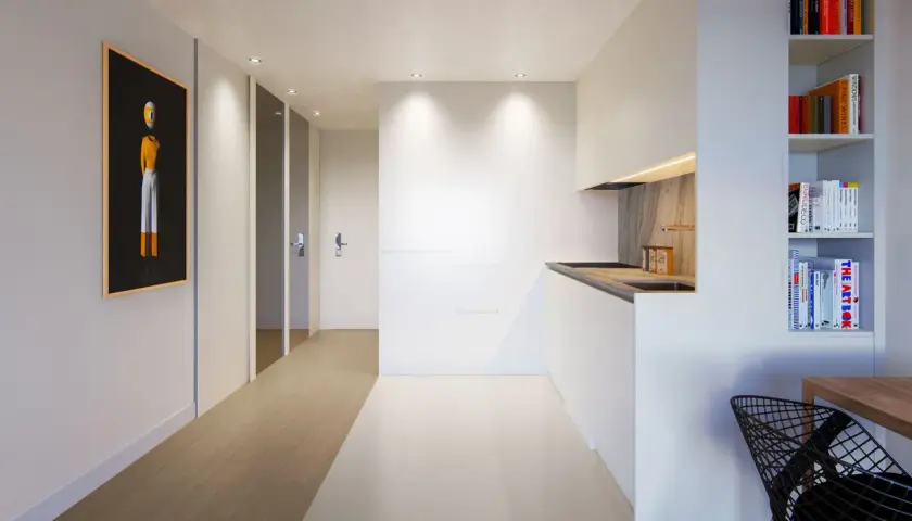 Pasillo moderno con arte abstracto y cocina minimalista, creando un ambiente de flujo luminoso.