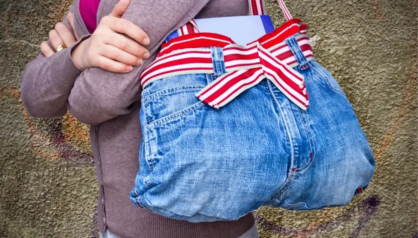 Kreative Tasche aus Jeans-Upcycling, mit rot-weiß gestreiftem Band und einer Schleife. Perfekt für Bücher und mehr.