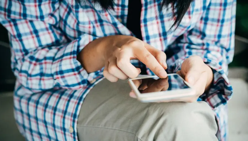 Mani che scorrono su uno smartphone, forse per esplorare il sexting perché si fa, un modo per connettersi.