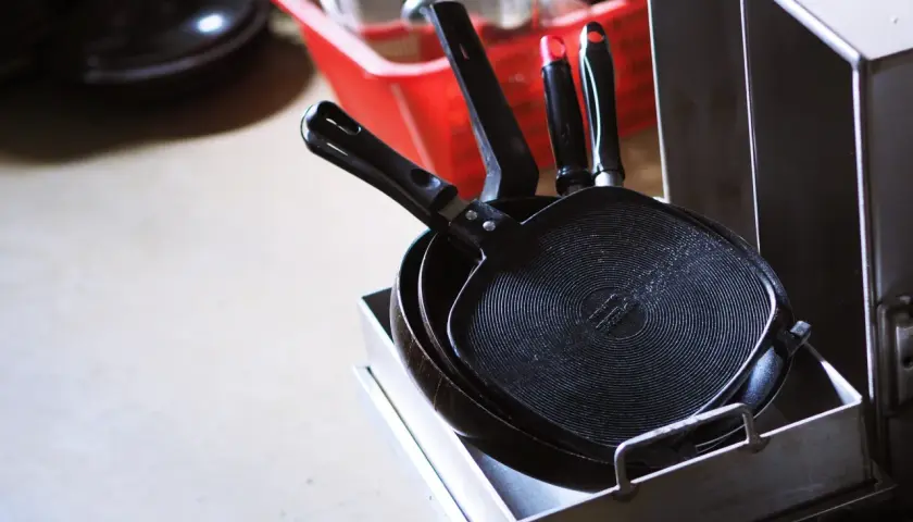 Poêles Tefal empilées, prêtes pour un nettoyage en profondeur. Apprenez comment nettoyer une poêle Tefal brûlée pour lui redonner son éclat.