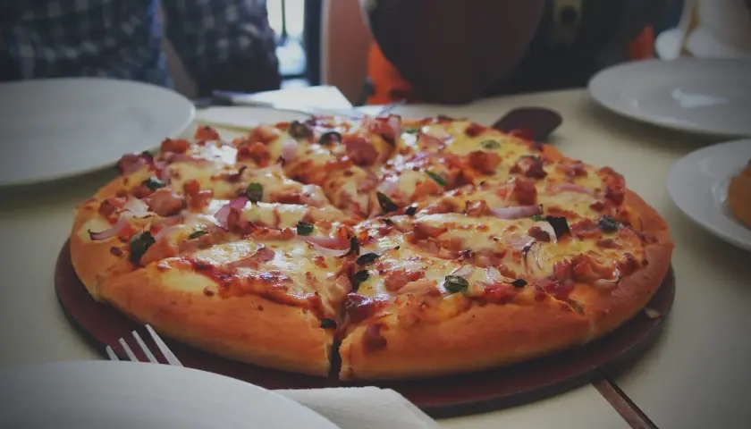 Pyszna, gorąca pizza z kurczakiem i cebulą, idealna do odgrzania zimnej pizzy.