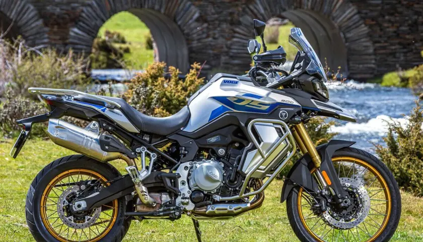 Moto Voge 500DS, una moto china con motor BMW, lista para la aventura junto a un puente de piedra.