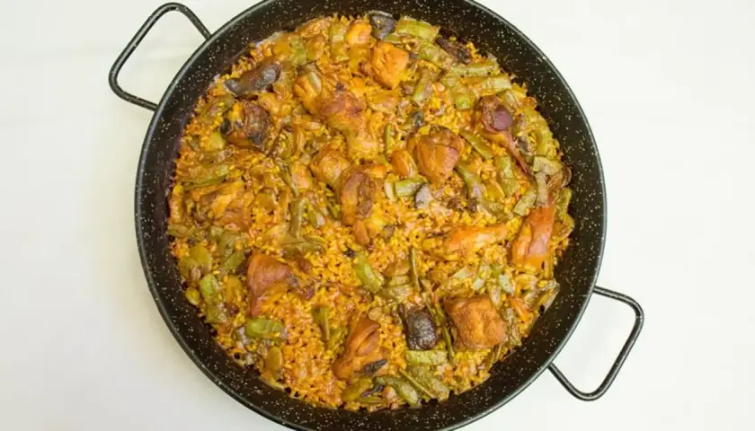 Paella mixta recién hecha, con pollo, judías verdes y arroz dorado. Un delicioso paella rezept para compartir.