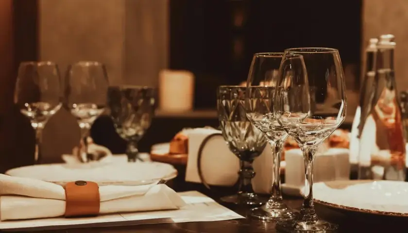 Table dressée avec verres à vin, serviette et bouteille d'eau.