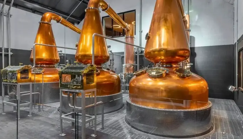 Alambics en cuivre brillants dans une distillerie, prêts à produire le meilleur whisky de Dublin.