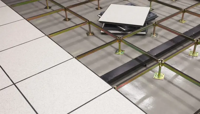Struttura metallica per pavimento rialzato interno, con pannelli bianchi posati e altri in attesa di installazione.