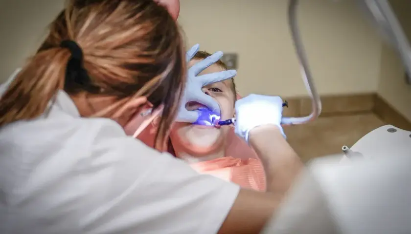 Dentysta leczy zęby dziecka w gabinecie stomatologicznym.