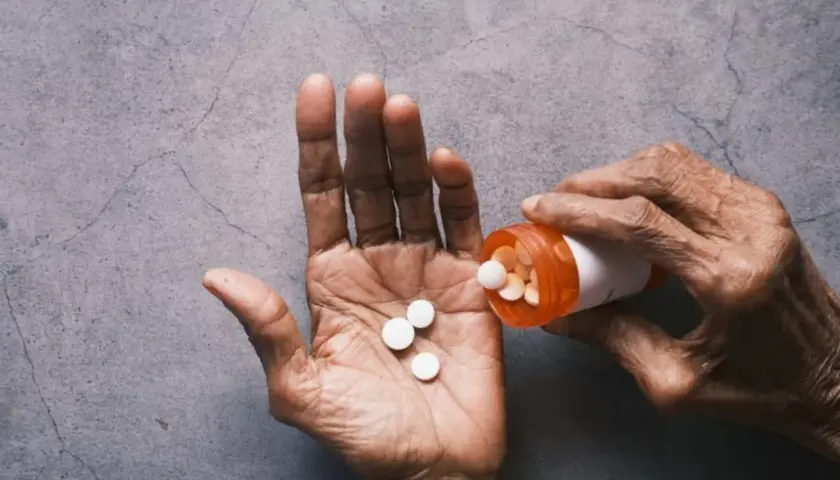 Dłoń wysypuje tabletki z buteleczki. Zastanawiasz się, tylenol co to? To lek przeciwbólowy.