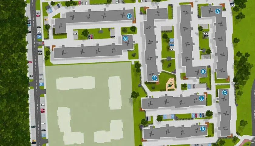 Widok z lotu ptaka na osiedle mieszkaniowe "Zielony Zakątek Toruń" z budynkami, parkingami, placem zabaw i terenami zielonymi.
