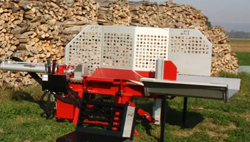 Roter Holzspalter mit silberner Verkleidung steht vor einem großen Holzstapel. Der Holzspalter fährt nicht hoch, was auf ein Problem hindeutet.