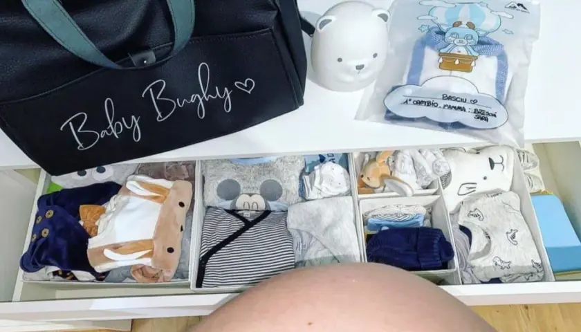 Borsa parto mamma: cosa mettere? Un cassetto organizzato con tutine, body e accessori per il neonato, pronto per l'arrivo.