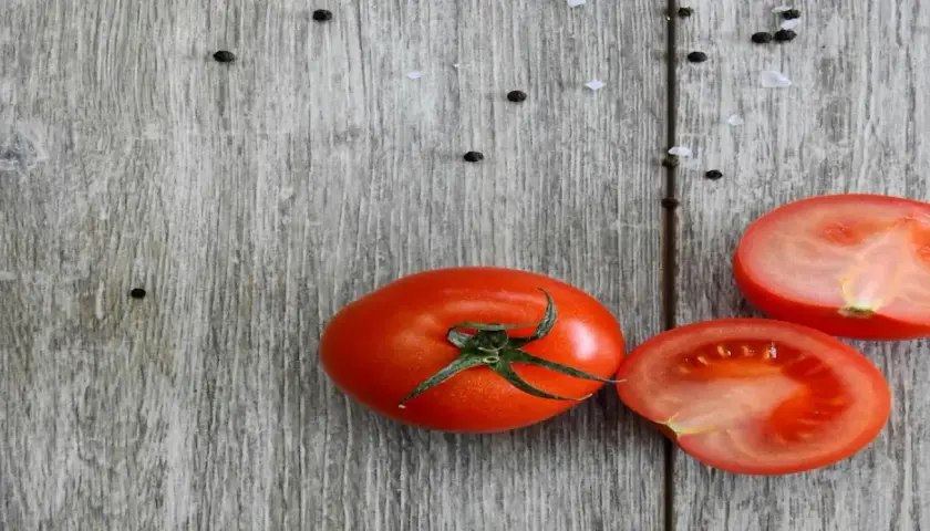 Frische Tomaten, reich an Lycopin, liegen auf rustikalem Holz. Die Lycopin-Wirkung ist bekannt für ihre antioxidativen Eigenschaften.