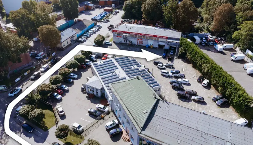 Widok z lotu ptaka na teren firmy Elektromatic Krawczyk Michał, z parkingiem pełnym samochodów i budynkami.