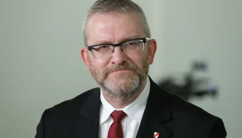 Grzegorz Braun w garniturze i krawacie, z okularami i brodą. Czy zostanie wykluczony z klubu za kontrowersyjne wypowiedzi o Izraelu?