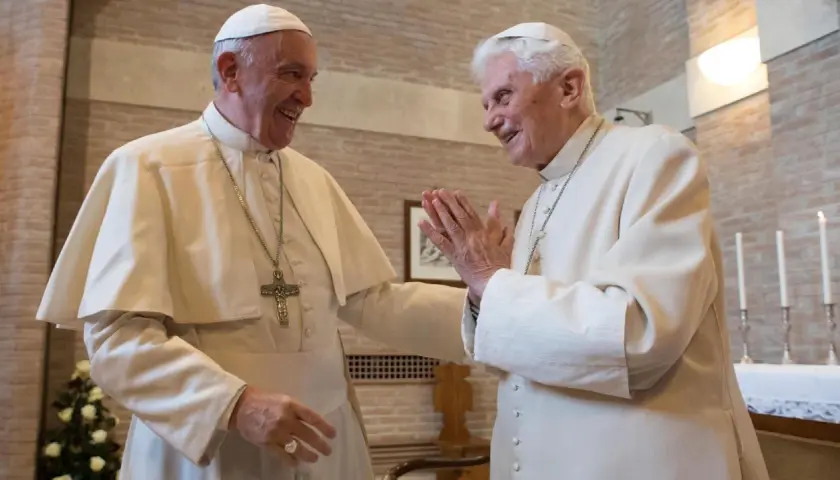 Zwei Päpste, Franziskus und Benedikt XVI., lachen sich an. Ihre Namen sind in der Geschichte des Papsttums unvergessen.