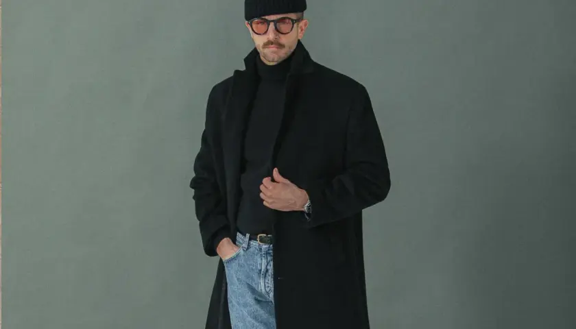Un homme porte un manteau noir, un pull à col roulé, un bonnet et des lunettes. Faut-il prendre une taille au-dessus pour un manteau ?