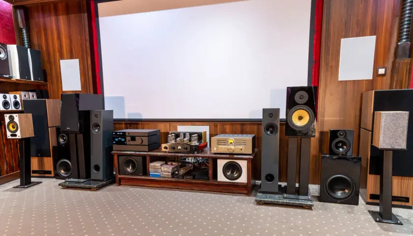Pokój kinowy z wieloma głośnikami i sprzętem audio, idealny dla każdego audiofila.