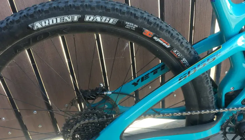 Close-up of a turquoise Yeti mountain bike rear wheel, featuring a Maxxis Ardent Race tire.