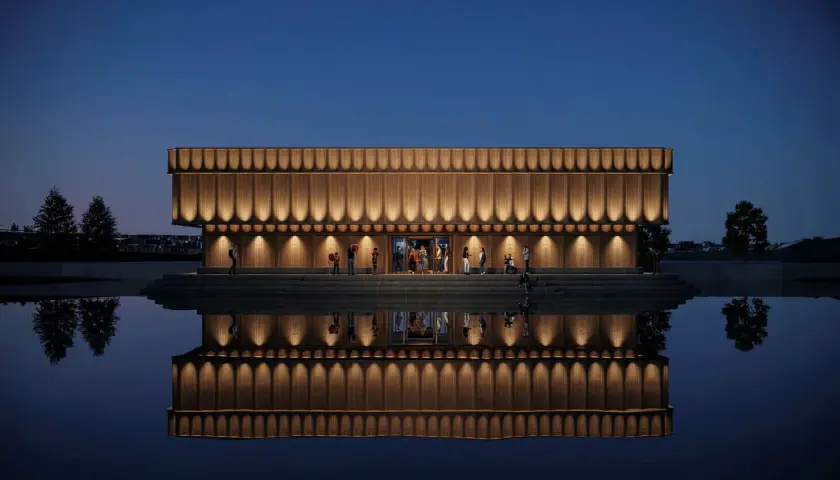 Elegant musik museum med träfasad och upplysta detaljer speglar sig i lugnt vatten.