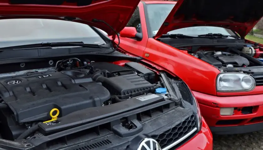 Dwa czerwone Volkswageny z otwartymi maskami, prezentujące swoje niezniszczalne silniki diesla TDI.