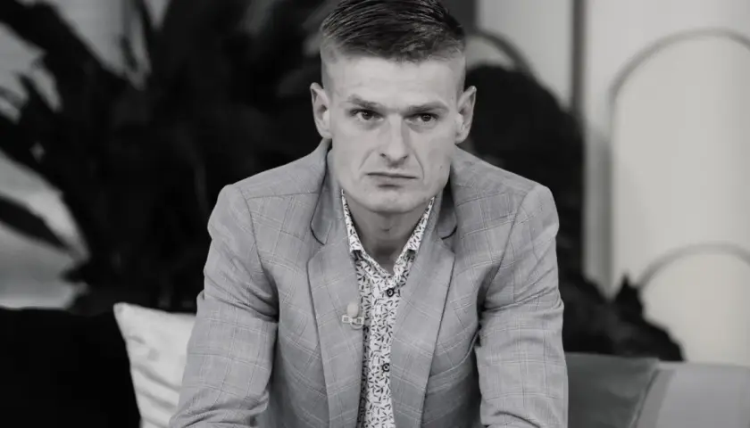 Tomasz Komenda, mimo młodego wieku, ma za sobą trudne doświadczenia. Na zdjęciu w garniturze i wzorzystej koszuli.