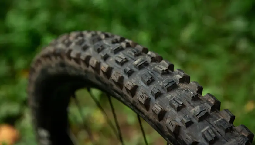 Close-up of a Maxxis Assegai tire, showing its aggressive tread pattern. This tire is ready for any trail.