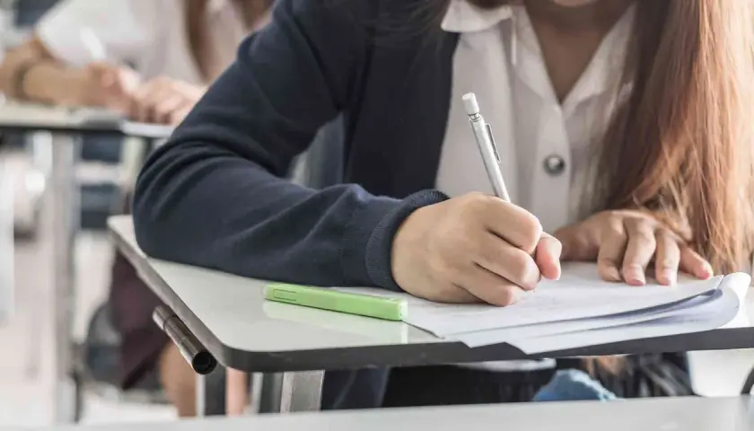 Uczeń pisze wypracowanie, ćwicząc użycie gerund i bezokolicznika.