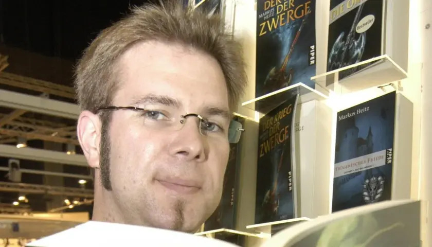 Markus Heitz, Autor von "Markus Heitz Die Zwerge Band 10", posiert vor seinen Büchern.
