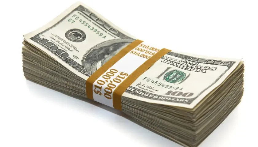 Stos banknotów 100-dolarowych związany papierową opaską z napisem $10,000.