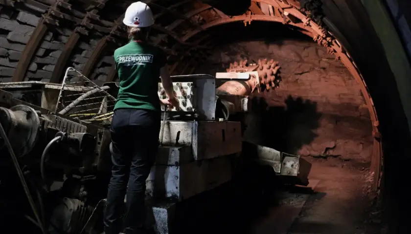 W kopalni Guido przewodnik w zielonej koszulce i kasku obsługuje maszynę. Warto wiedzieć, jak się ubrać na taką wycieczkę.