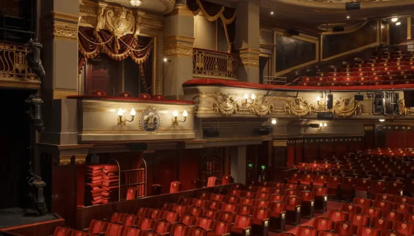 Luksusowe wnętrze teatru z czerwonymi fotelami i złotymi zdobieniami. Zastanawiasz się, ile trwa przedstawienie w teatrze?