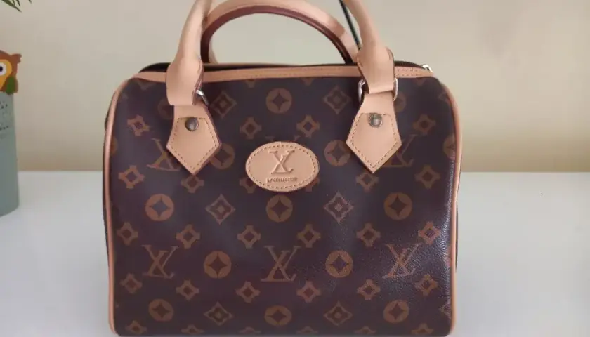 Elegancka brązowa torebka z monogramem, przypominająca luksusowe marki torebek. Idealna na co dzień i specjalne okazje.