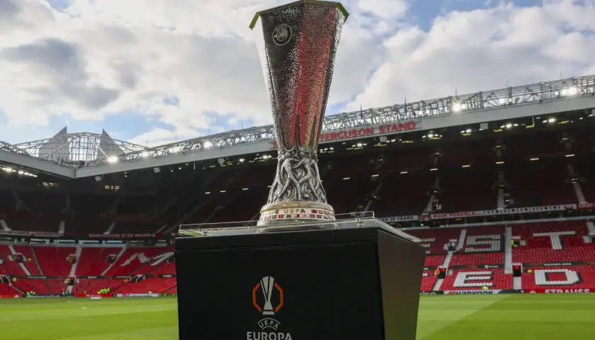 Trofeum Ligi Europy na tle stadionu Old Trafford. Marzenie o tym, by zdobyć ten puchar, jest bliskie spełnienia dla wielu drużyn.