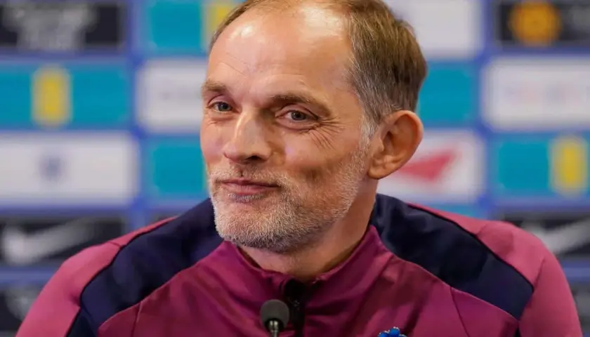 Thomas Tuchel, były trener Chelsea, w bordowej kurtce z niebieskimi wstawkami, z przypinką w kształcie niebieskiego kwiatka.